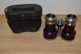 A pair of leather clad opera glasses with case.