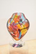 A heavy multi coloured mottled art glass vase, sat on clear glass foot.