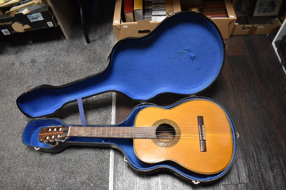 A vintage six string and full sized acoustic guitar with hard shell case