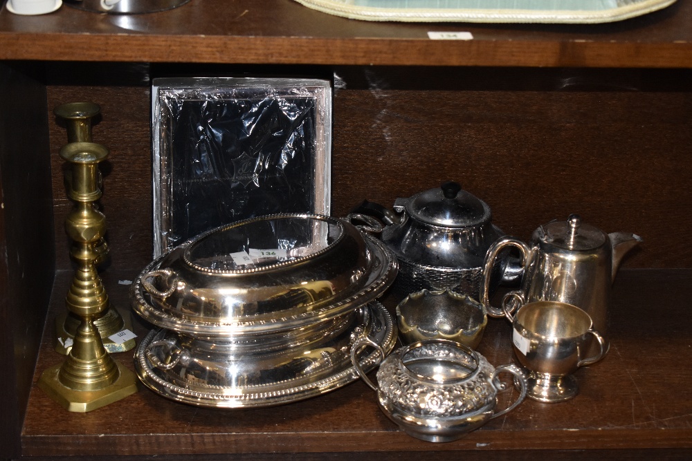 Two silver plated entree dishes, two brass candlesticks, a contemporary white metal photograph