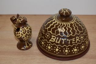 A glazed slipware terracotta butter dish and a whistle, in the manner of Wetheriggs pottery.