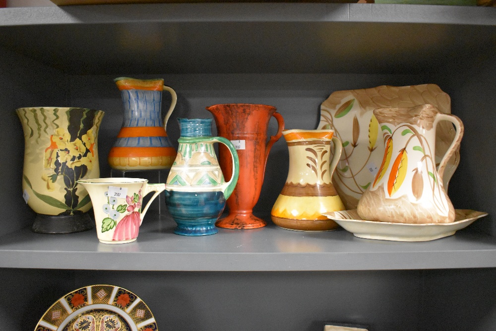 A selection of bright Art Deco hand painted Myott pottery, including jugs, plate and vases.