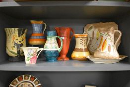 A selection of bright Art Deco hand painted Myott pottery, including jugs, plate and vases.