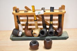 A vintage pipe rack and six tobacco pipes.