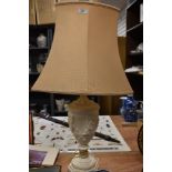 A 20th Century resin urn form table lamp decorated with a classical design, with shade, measuring