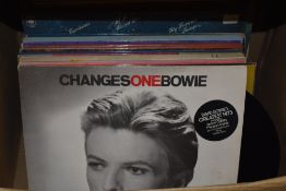 A box of assorted vinyl records, including David Bowie 'Changes', Nat King Cole 'Unforgettable', '