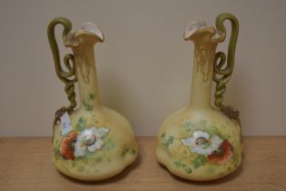A pair of early 20th century Vienna porcelain ewers, having twist handle and poppy decoration with