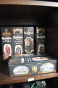 Five vintage Glenfiddich Scotch whisky tins.