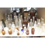 A large collection of vintage glass bottles and jars , including advertising bottles of interest