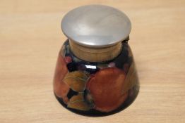 An early to mid 20th century Moorcroft ink well, having blue ground with tube lined fruit design.