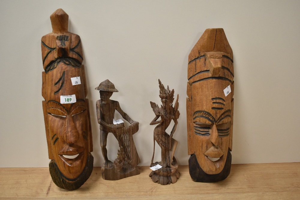 Two carved treen tribal masks and two finely carved figurines.