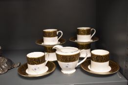 Six Minton 'Grandee' coffee cans and saucers and a cream jug, having white ground with black band