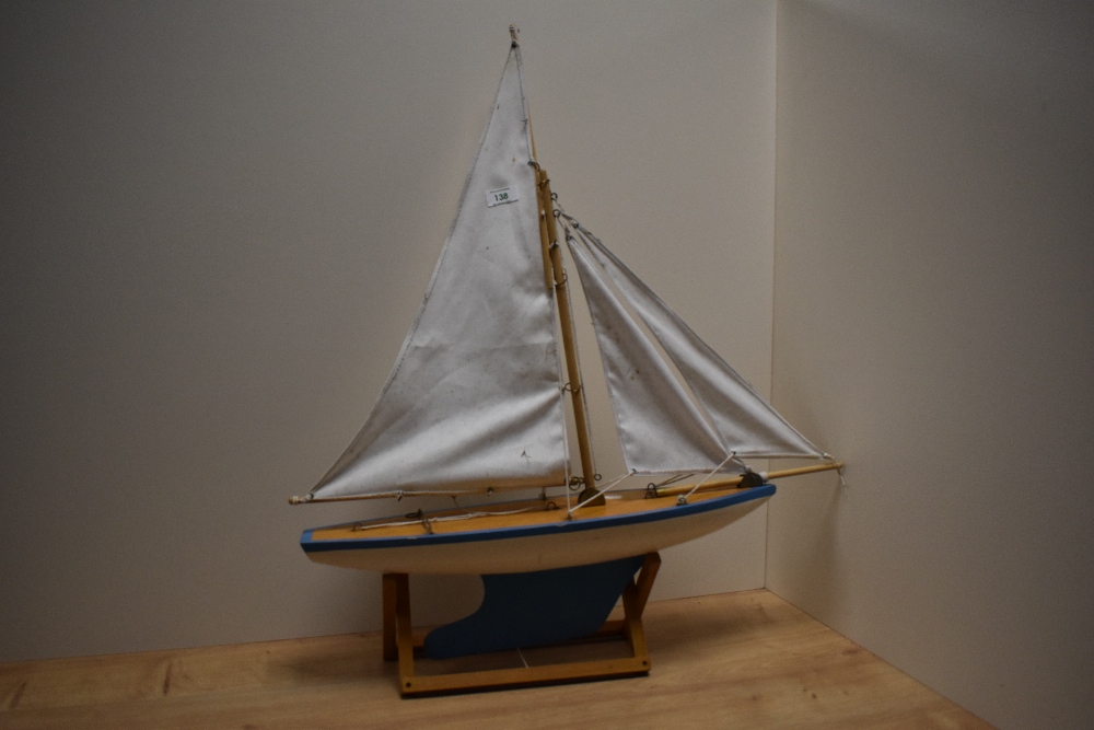 An early-mid 20th Century painted wooden pond yacht with sails, measuring 54cm long