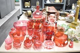 A collection of cranberry glass jugs, pinch pots, vase, glasses etc, also included are two