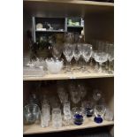 A large collection of glass ware, including bowls, wine glasses, cut glass tumblers, butter dish and
