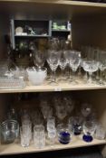 A large collection of glass ware, including bowls, wine glasses, cut glass tumblers, butter dish and