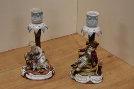 A pair of late 19th/early 20th century Sitzendorf porcelain figural candlesticks, one ornamented