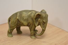 A 1930's Royal Dux porcelain elephant figure, in olive green with gilt embellishment, impressed