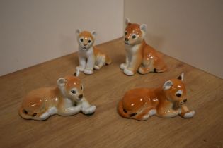 A group of four USSR Russian Lomonosov porcelain animal figures, four lion cubs, two laying, two