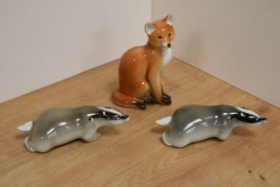 A group of three USSR Russian Lomonosov animal figures, comprising red fox and two badgers,