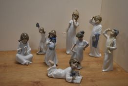 A group of eight Nao by Lladro porcelain figures and figurines, depicting children dressed in