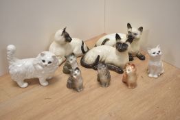 A collection of nine Beswick Pottery and Royal Doulton cat and kitten studies, to include Siamese