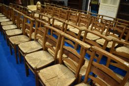 A set of six rush seated chapel chairs having ladder backs, with hymn/prayer book shelves