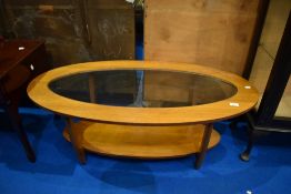 A vintage teak and glass coffee table of oval form, approx 117 x 54cm