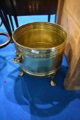 A vintage brass coal bucket having lion mask handles and paw feet