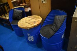 A patio set , constructed from oil drums, with New Holland branding, comprising two seats and