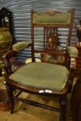 A late Victorian/Edwardian mahogany salon armchair having inlaid decoration to back, upholstered