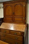 A 19th Century golden oak bureau having shell and moth designs , brass hinges to bookcase door and