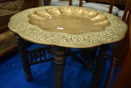 An Anglo Indian style brass scallop top occasional table on typical folding treen support,