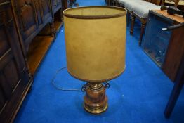 A decorative table lamp, having brass base and turned centre, with candle effect lamp holder and