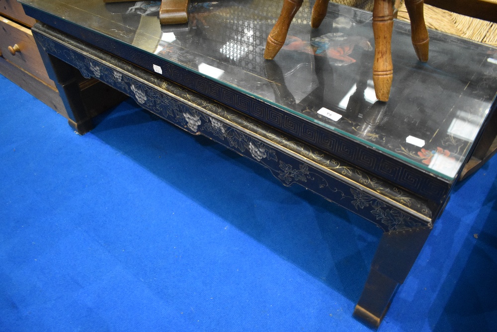 A Japanesque black laquered coffee table, with horse decoration, approx 117 x 46cm, height 47cm