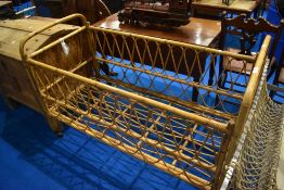 A vintage wicker cot, dimensions approx L132cm W60cm H91cm