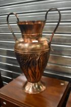 A vintage copper two handled urn shaped vase or similar container, having planished and hammered