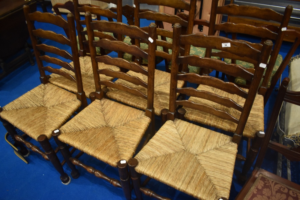 A set of six traditional oak ladder back chairs having rush seats