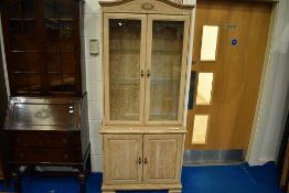 A modern laminate limed oak effect display cabinet with double cupboard under, dimensions approx.