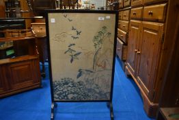 A vintage embroidered fire screen