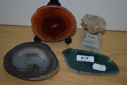 Three slices of polished agate in green orange and white colours along with an agate stone on a