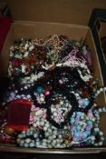 An assorted collection of costume jewellery, including a string of pink plastic beads, a white metal