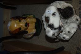 Two vintage chalkware carnival dog ornaments, the largest measures 29cm tall