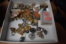 An assorted collection of costume jewellery, including daisy design earrings, an eastern filligree
