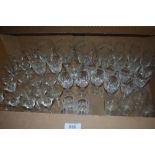 A carton containing a selection of cut and etched glass wine and spirit glasses.