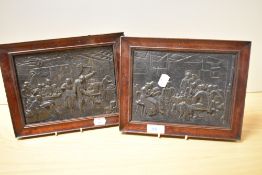 A pair of 19th Century cast metal plaques depicting Dutch tavern scenes and displayed within stained