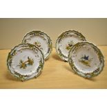 Four French Quimper ware style saucers, hand decorated with scenes from nature, diameter 14cm