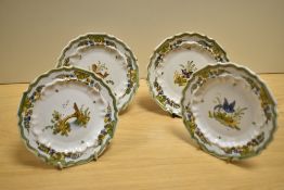 Four French Quimper ware style saucers, hand decorated with scenes from nature, diameter 14cm