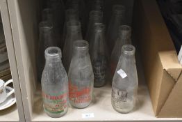 A collection of vintage glass milk bottles with adverts, of Kilbride, Longridge, Knottend interest