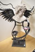 A bespoke Neoclassical Revival style candle stand, wrought iron and winged, having a central,